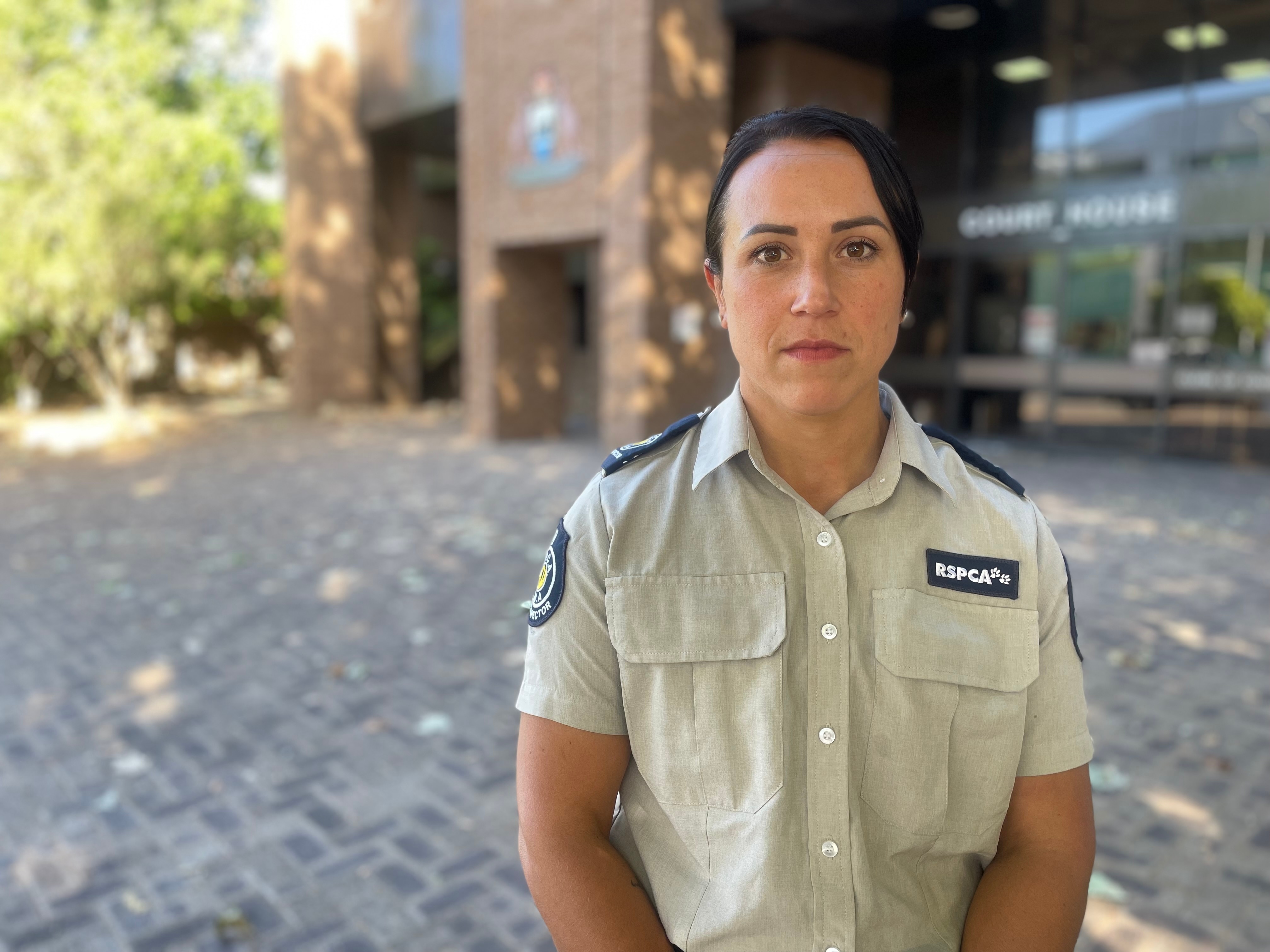 Image of a woman wearing a khaki rspca uniform outside a courthouse.