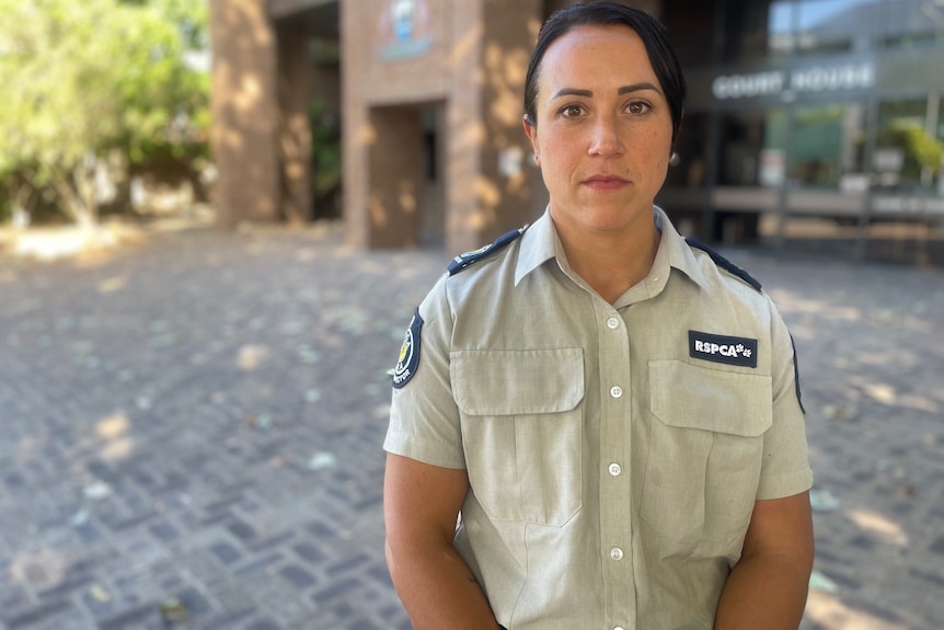 Image of a woman wearing a khaki rspca uniform outside a courthouse.