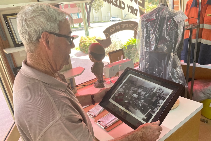 An older gentleman observes a framed picture
