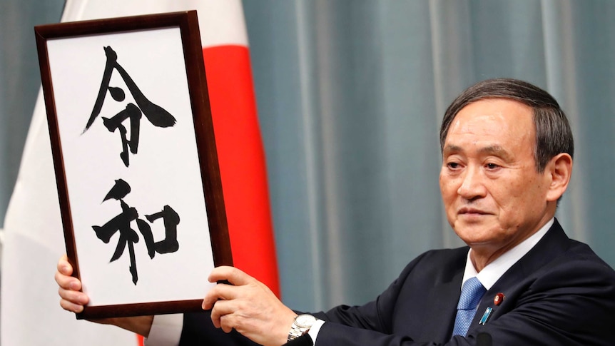 Japan's Chief Cabinet Secretary Yoshihide Suga holds a sign to unveil the name of new era "Reiwa".