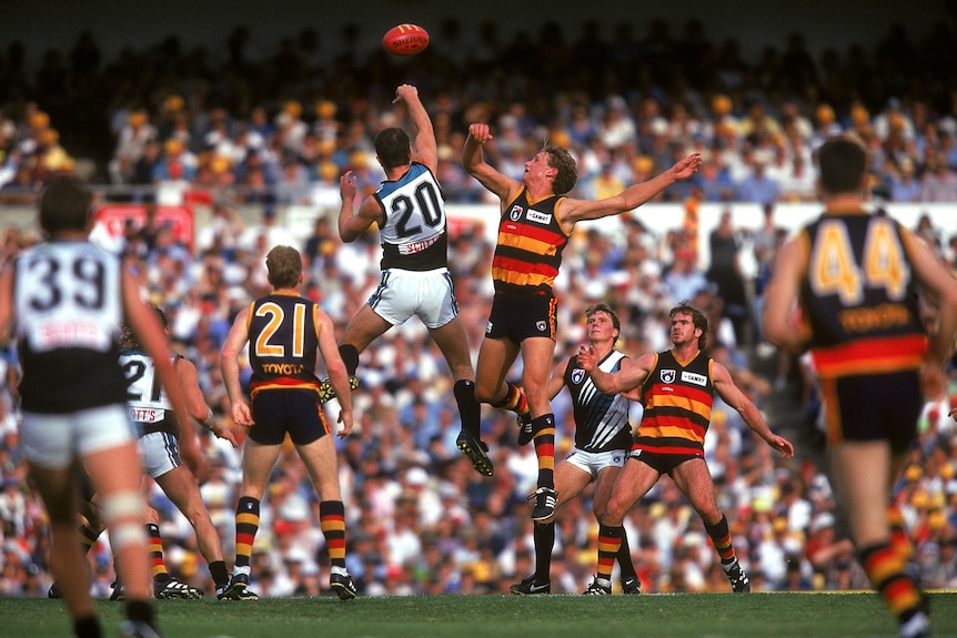 Two men jump in the air contesting a football