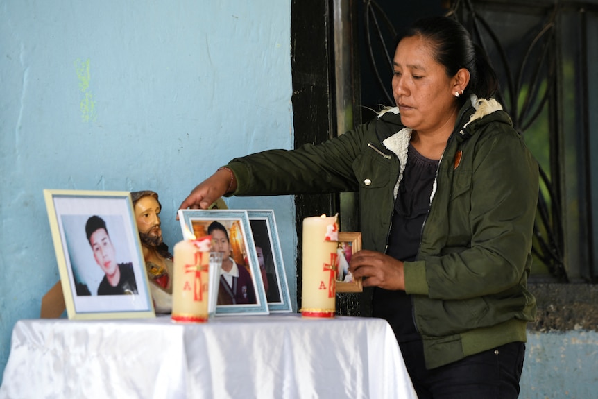 Yolanda Olivares, arranges pictures of her sons Jair, 19, Yovani Valencia, 16, and her nephew Misael Olivares.