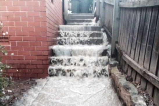 Water pours down a flight of stairs