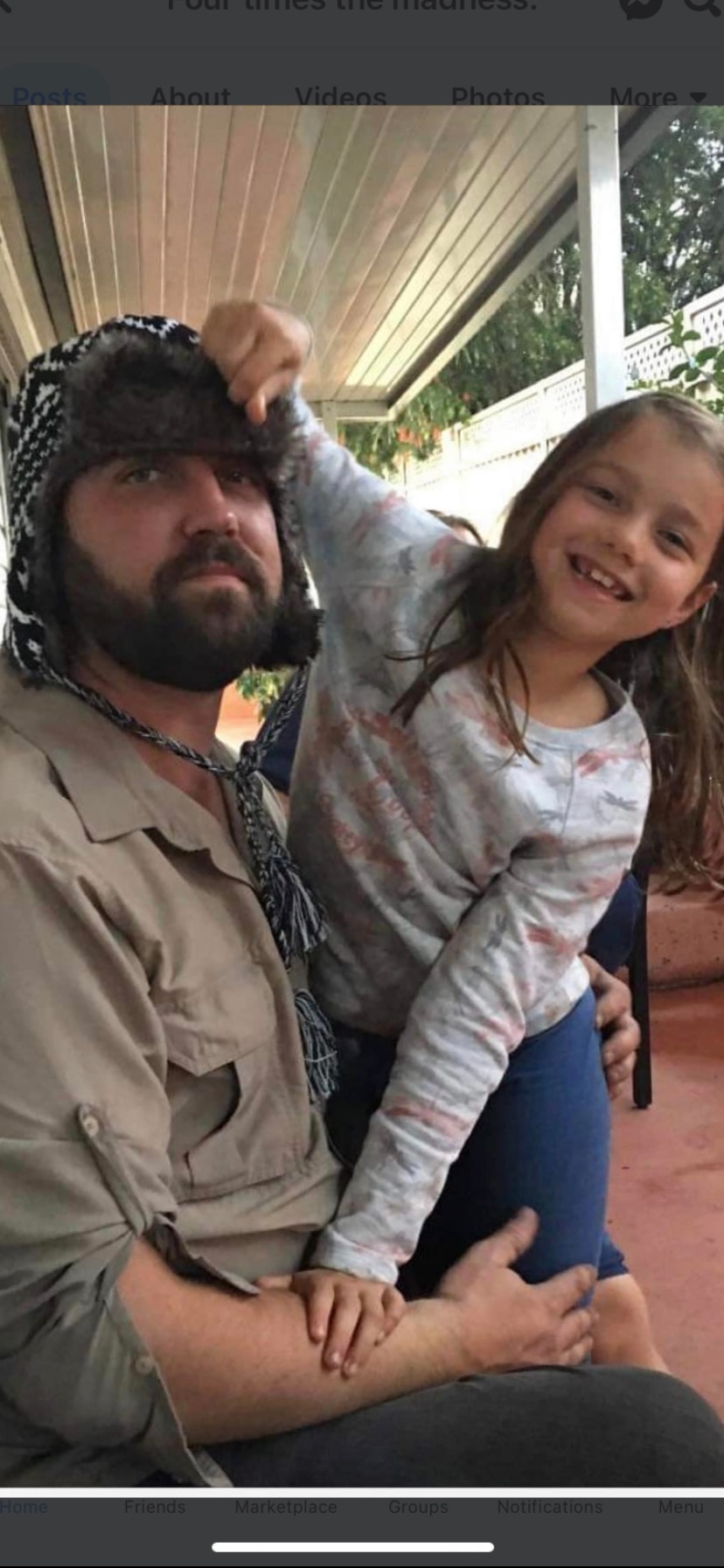 A man wearing a beanie, looking serious, with a smiling 10-year-old girl.