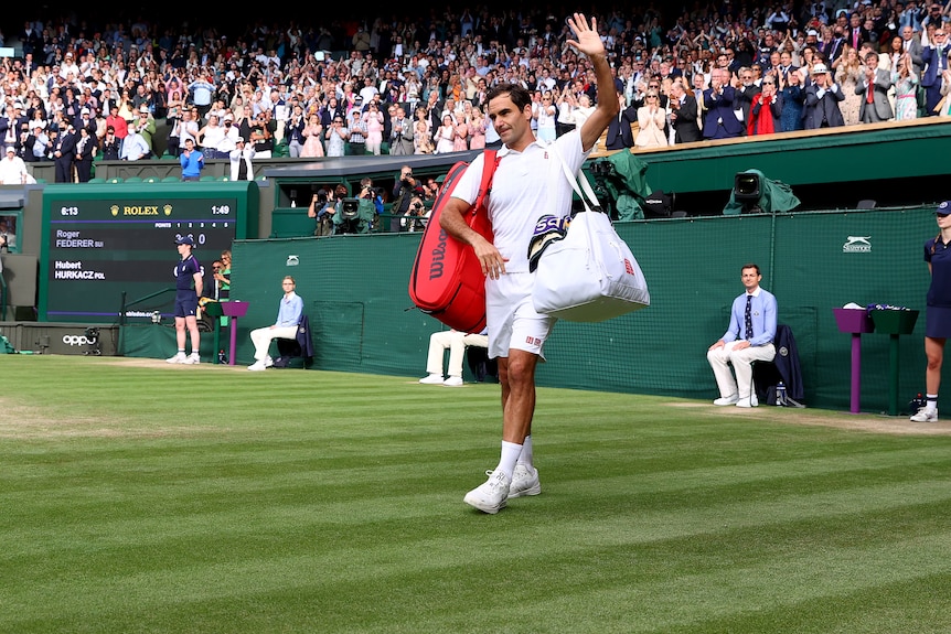 Roger Federer waves to the Wimbledon crowd.