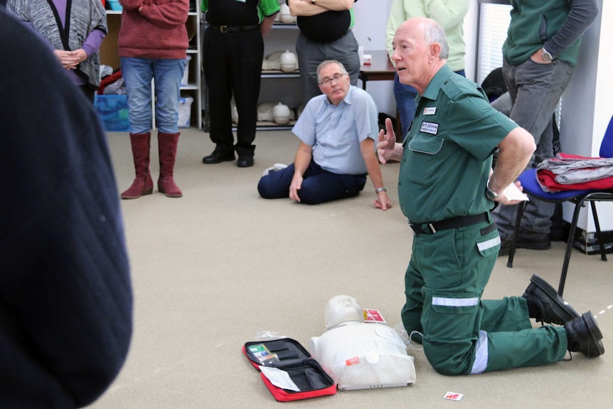 Volunteer Greg Whitfield demonstrates how to use an AED in a first aid workshop. June 2017.