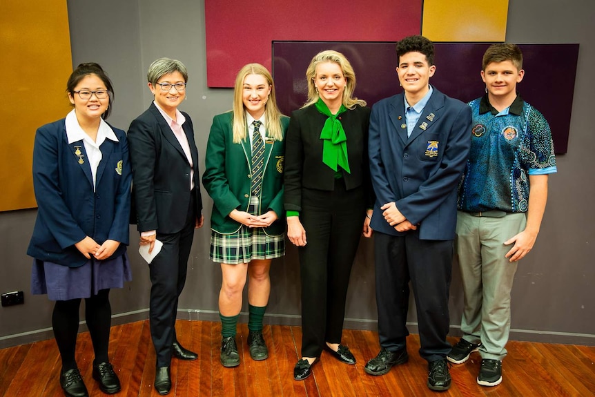 A group photo shows high schoolers Joanne Tran, Holly Cooke, Reuben Davis, Dylan Storer with Penny Wong and Bridget McKenzie