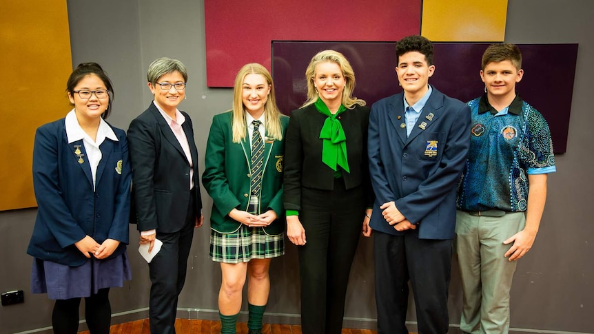 A group photo shows high schoolers Joanne Tran, Holly Cooke, Reuben Davis, Dylan Storer with Penny Wong and Bridget McKenzie