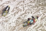An aerial view of surf life saving jetskis in surf.