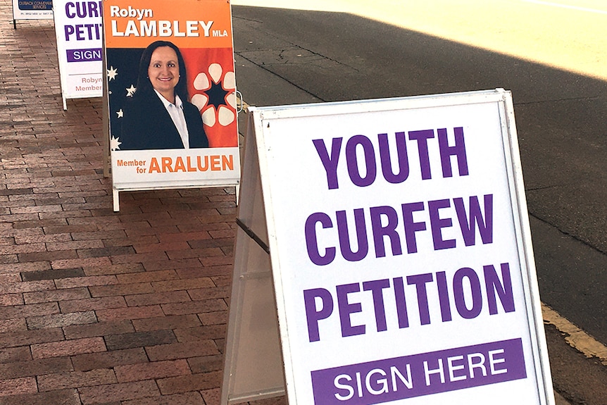 Signs on a footpath calling for a youth curfew