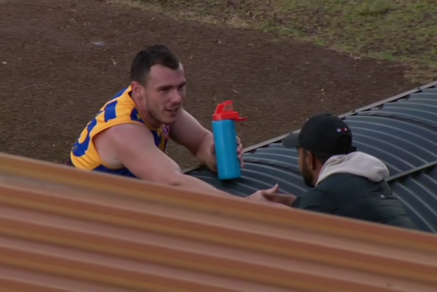 A photo of Luke Shuey shaking Willie Rioli's hand.