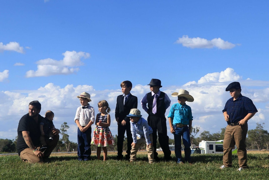 Children standing on a hill at the Barcaldine turf track in their best races outfits