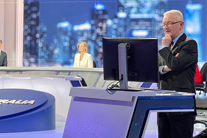 Green looking at computer with host Leigh Sales at desk in the background.