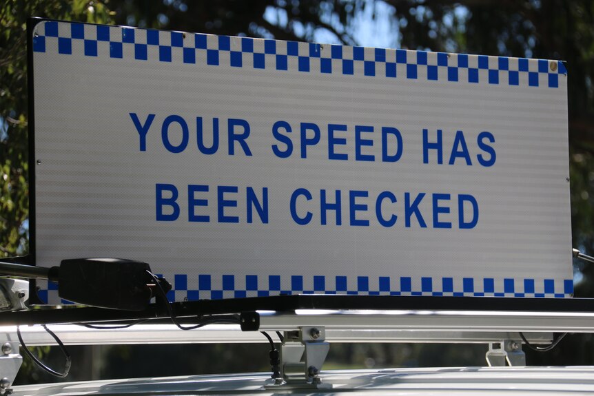 A sign saying 'Your speed has been checked'.