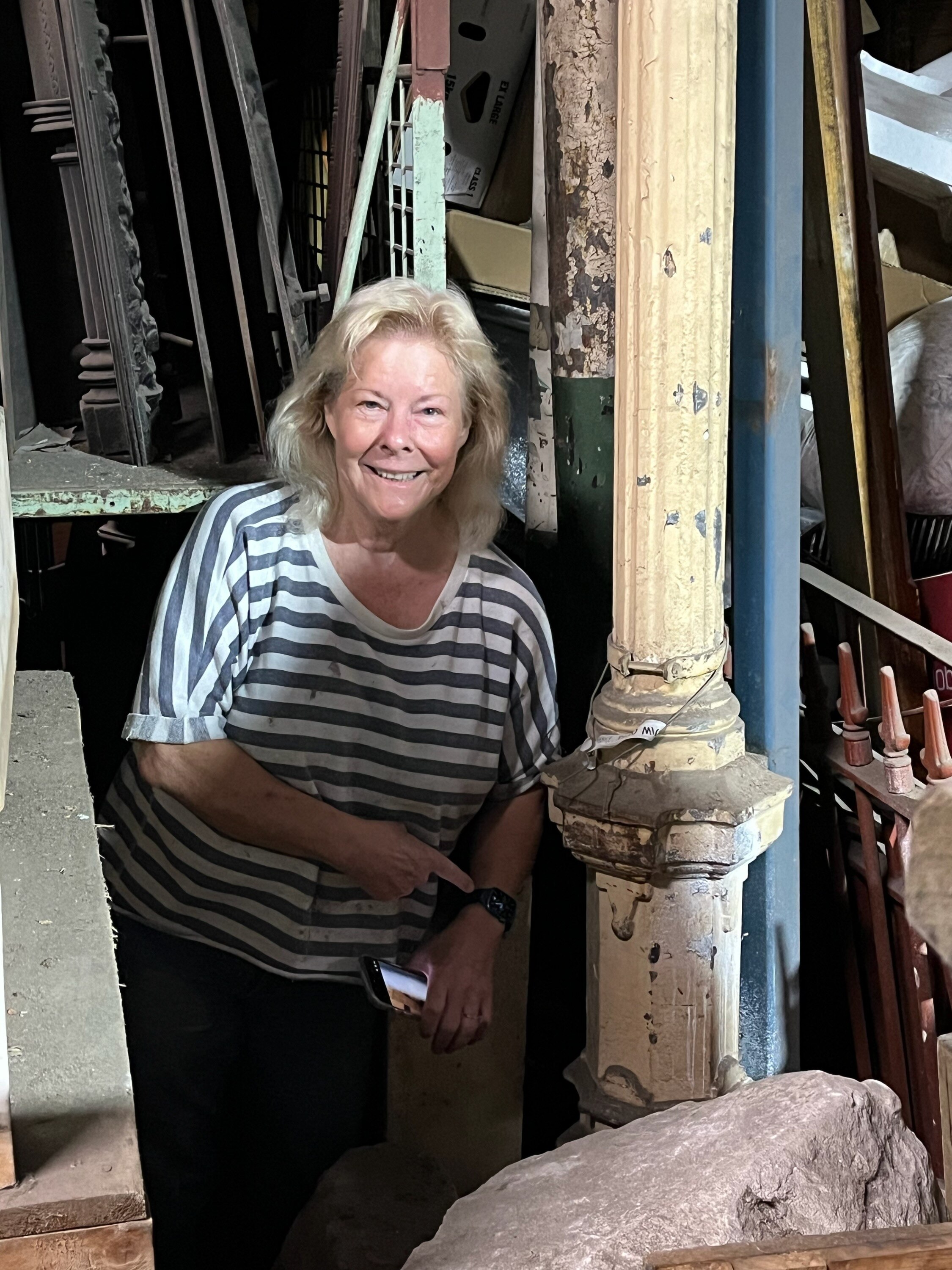 Uma mulher ao lado de um pedaço de metal.