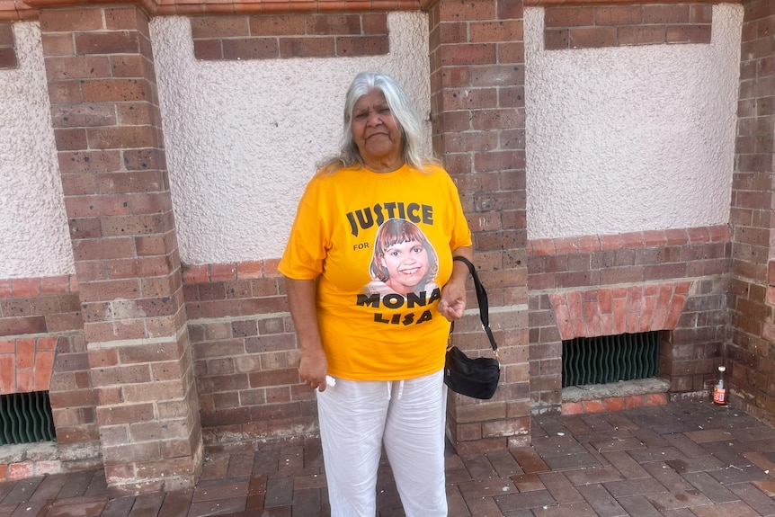 Woman wearing yellow T-shirt stating 'justice for Mona Lisa