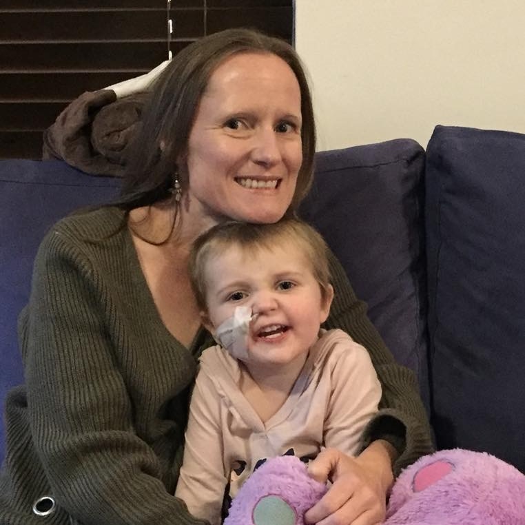 Jolyn Phillipps sits on a couch with her daughter Codee-Jo sitting in her lap