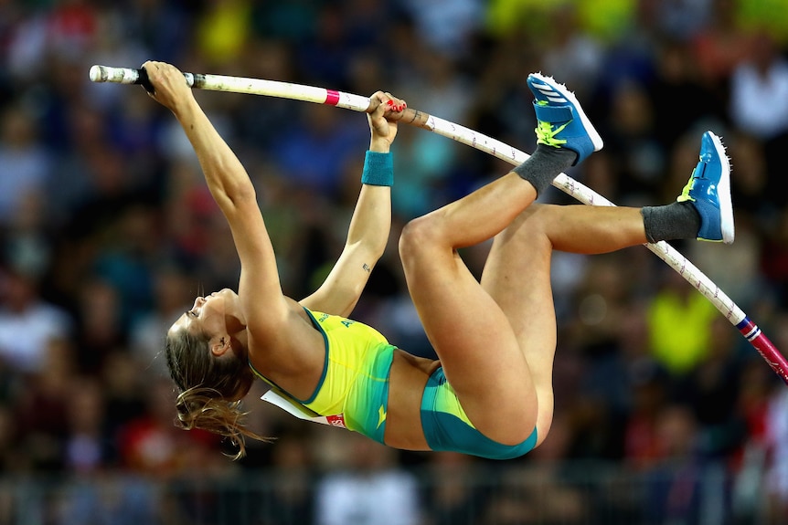 Female athlete in the middle of pole vaulting