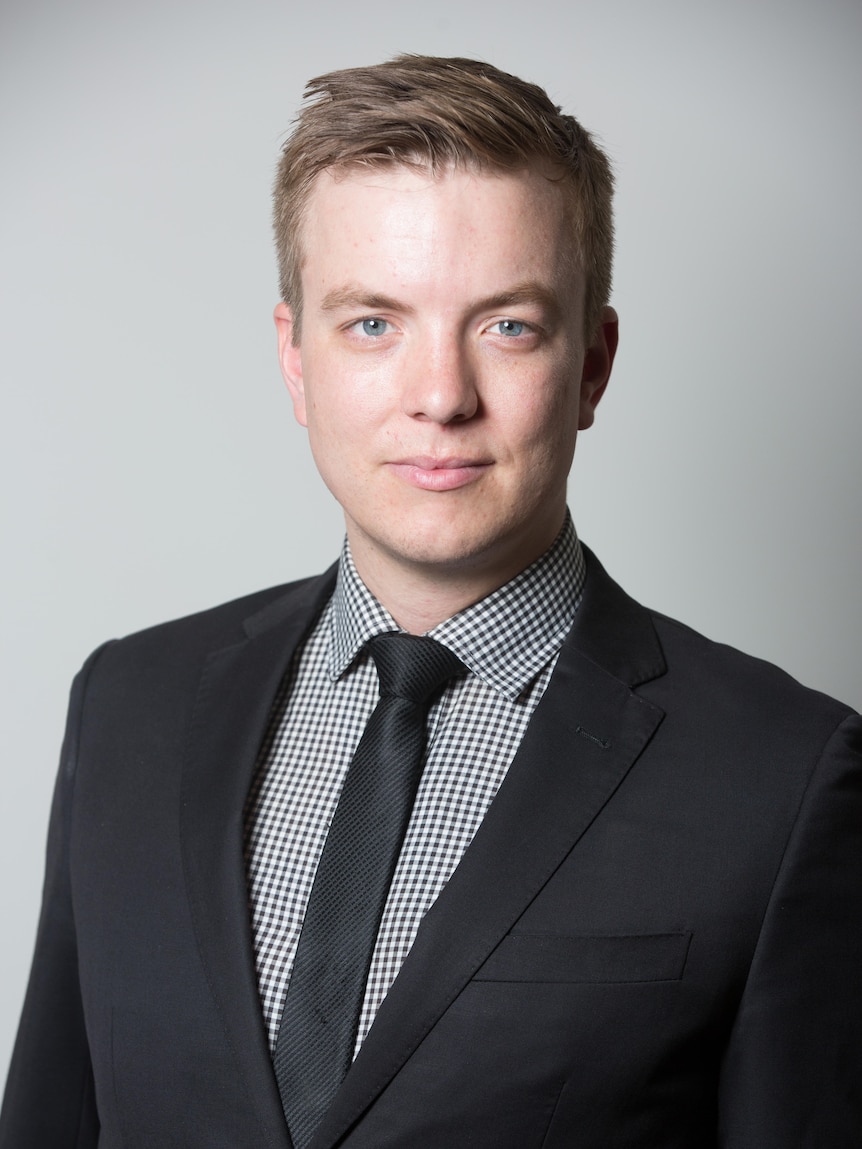 Headshot of a young man in a suit.