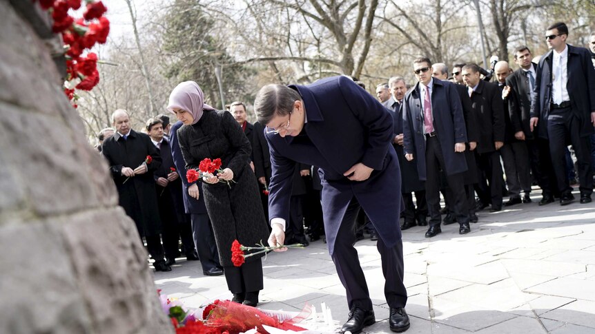 Turkish Prime Minister Ahmet Davutoglu places carnations at the site of the Ankara bombing.