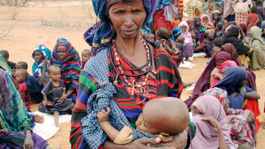 Starving and desperate: refugees and children wait to go to a refugee camp in Ethiopia