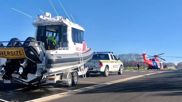 A fishing boat in front of a rescue helicopter.