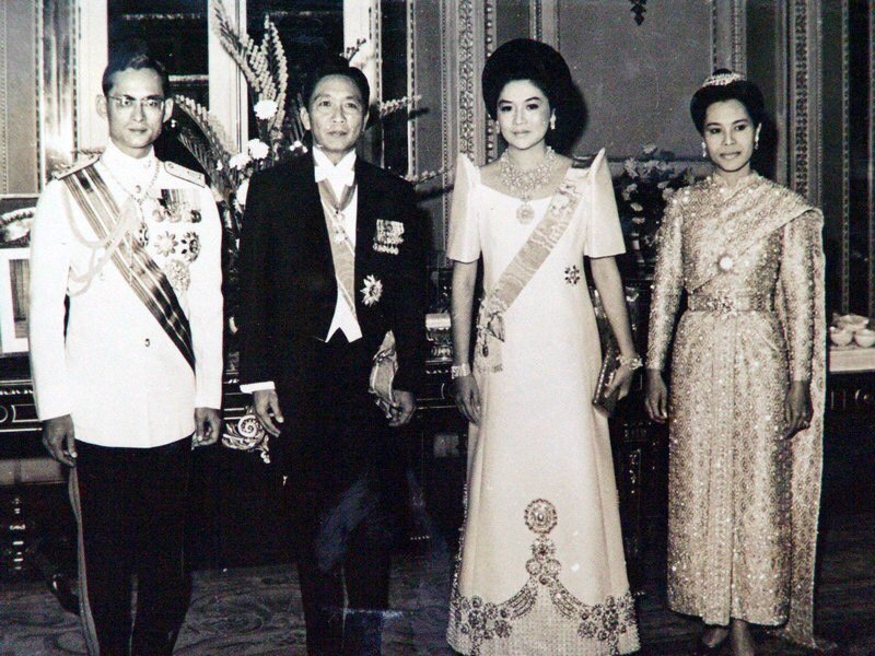 A black and white photo of Imelda and Ferdinand Marcos dressed in finery and adorned with jewels.