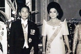 A black and white photo of Imelda and Ferdinand Marcos dressed in finery and adorned with jewels.