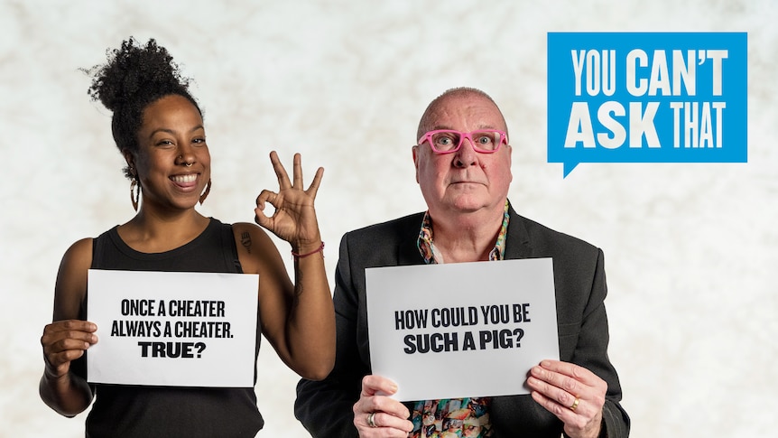 Woman holds sign reading 'once a cheater, always a cheater. True?' and a man holds a sign reading 'how could you be such a pig?'