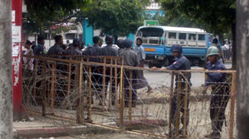 Soldiers stand behind a barricade in Rangoon.