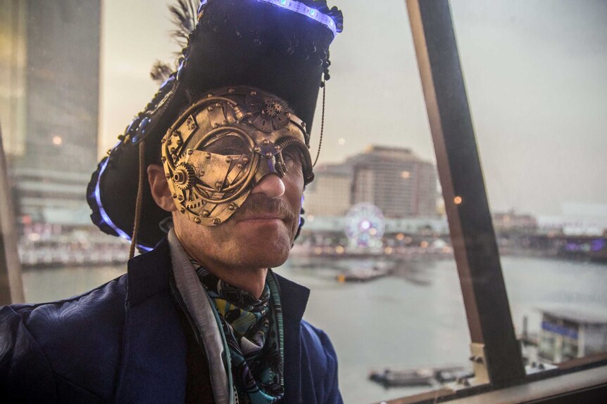 A man wearing a pirate hat with a brass face mask.