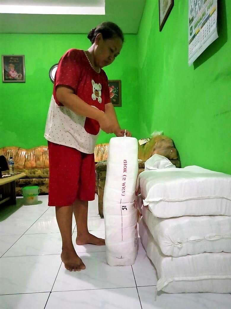 A woman standing and tie a big sack