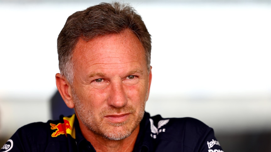 Christian Horner, in a blue polo shirt, looks into the distance during a practice session.