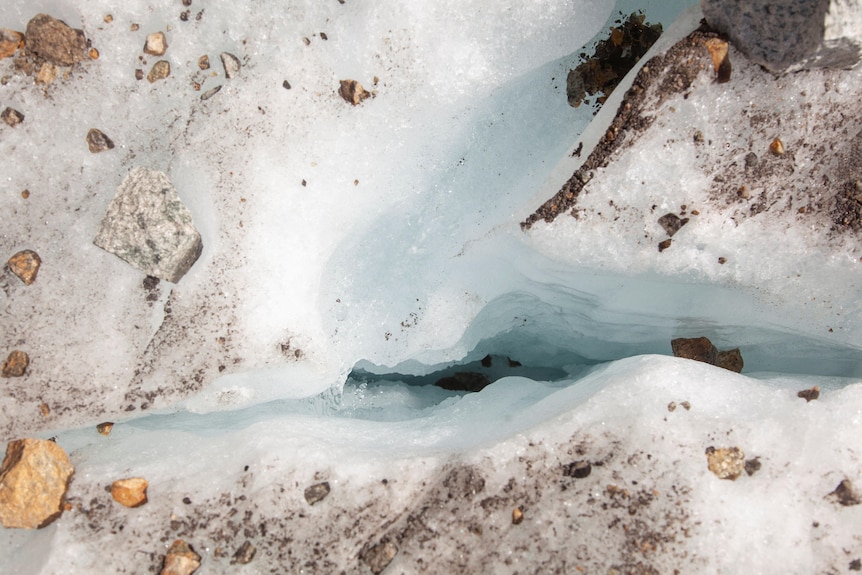A view from above of ice water flowing through a glacier. 