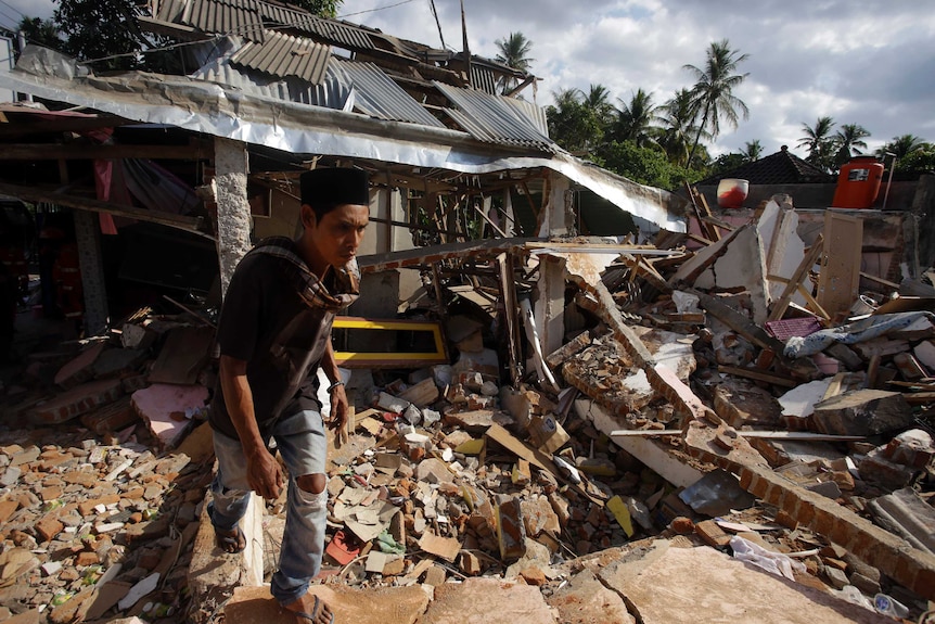 Man walks away from destroyed home.