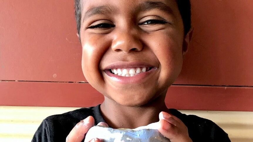 child smiling with pottery