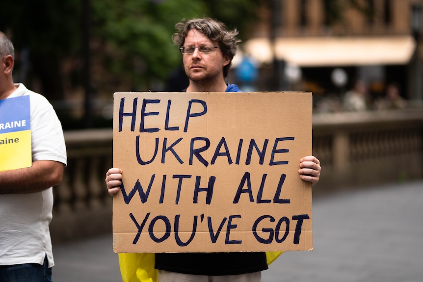 People seem protesting with Ukrainian flags and signs