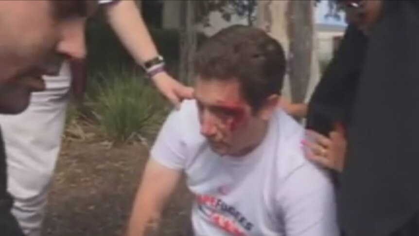 An anti-halal protester nurses injuries after an altercation at a rally in Melbourne