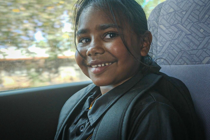 Smiling schoolgirl on bus.