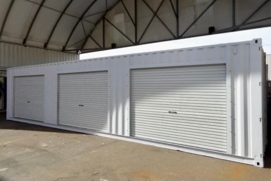 A container ship with three roller doors.