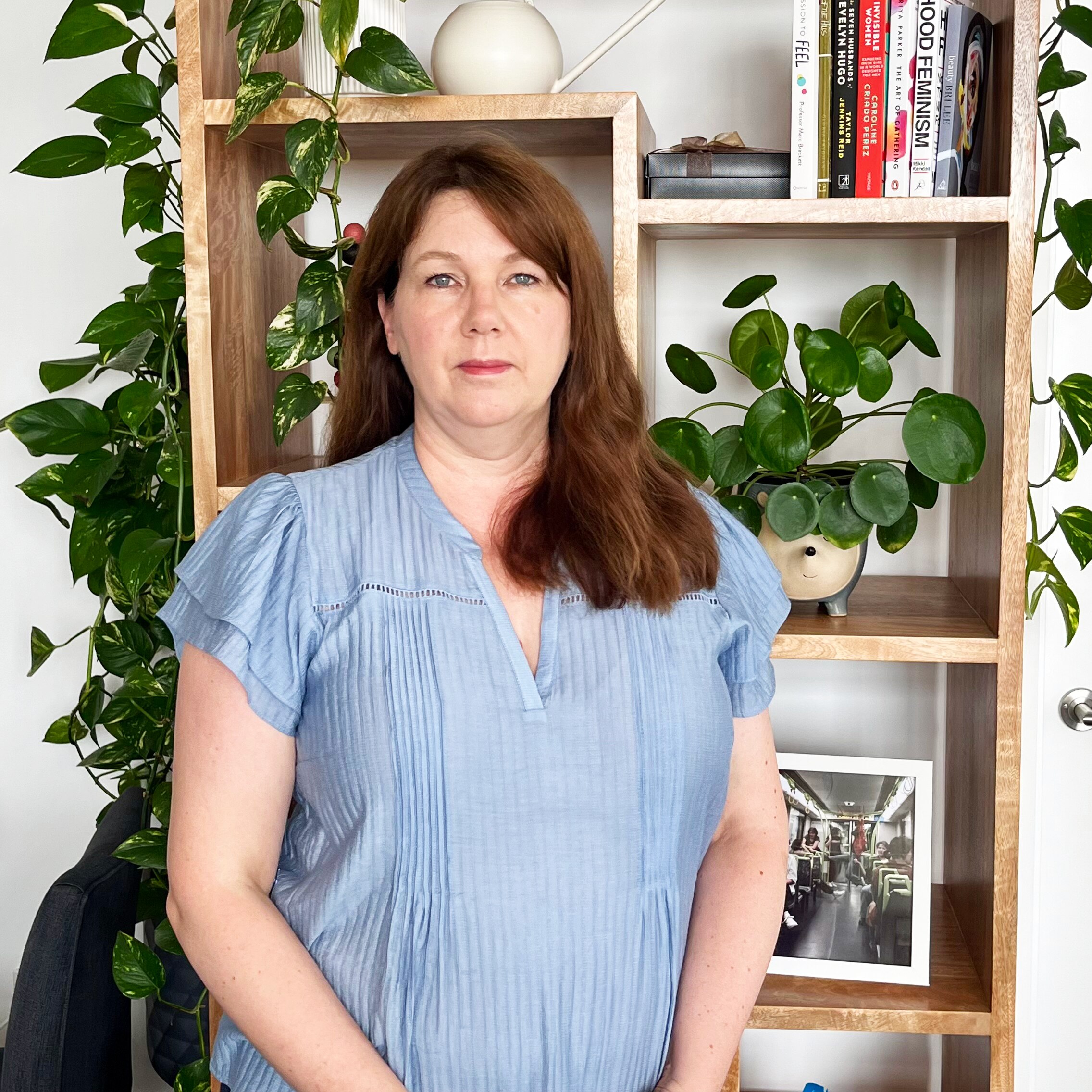 A woman standing in front of a book shelf.