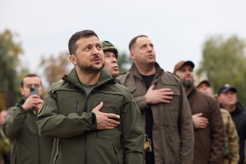 Le président ukrainien Volodymyr Zelenskyy chante l'hymne national ukrainien lors de sa visite à Izium.