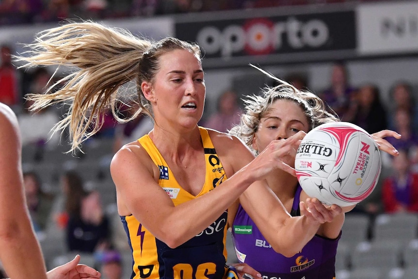A Sunshine Coast Lightning Super Netball player catches the ball in two hands against the Queensland Thunderbirds.