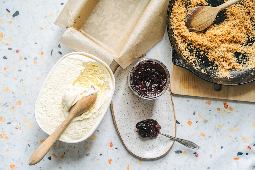 Vanilla ice cream, raspberry jam and toasted coconut, ingredients to make lamington ice cream cake.