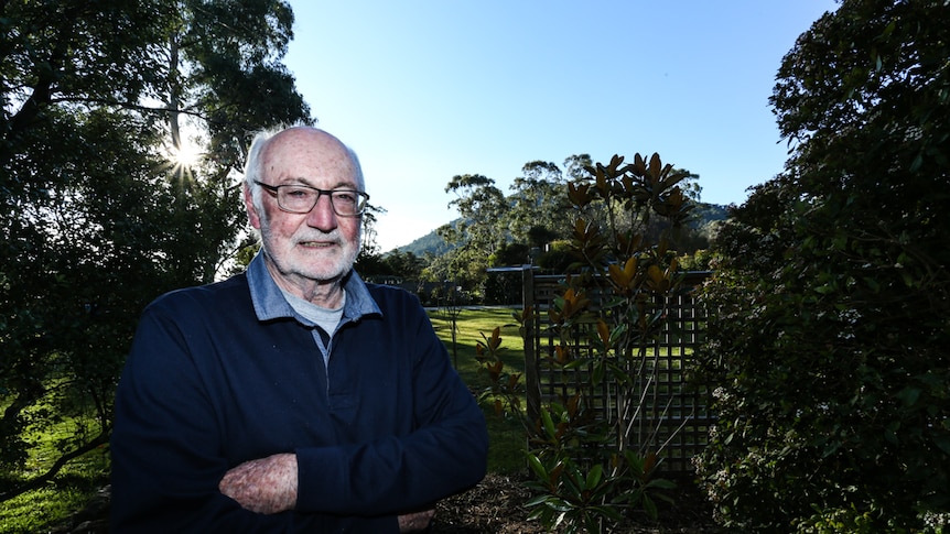 Athol Guy in his backyard with Mount Macedon behind him.