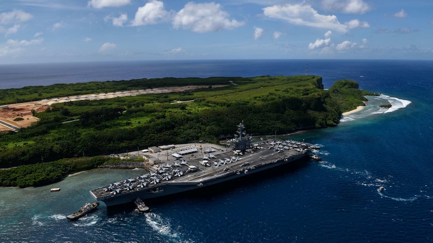 The aircraft carrier USS Theodore Roosevelt departs Naval Base Guam.