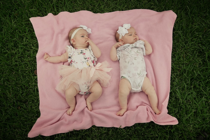 Twins Elyse and Evelyn on a pink rug