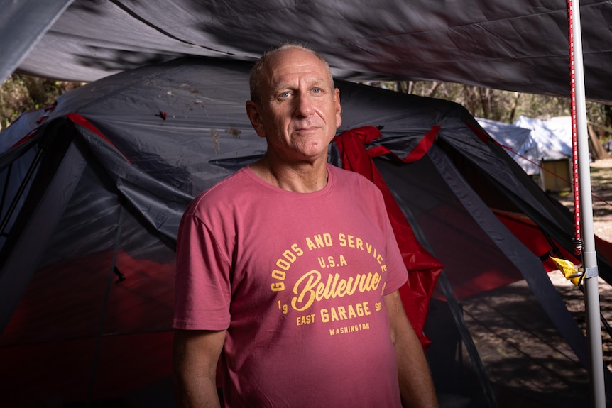 A man standing next to a tent