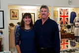 A man and woman stand in a room filled with military memorabilia