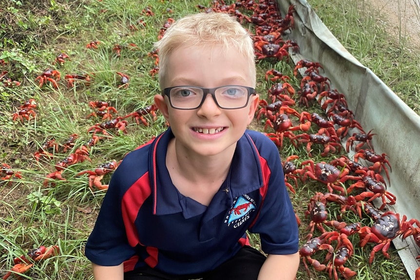 Christmas Island resident Jacob Tiernan-Luetich crouching next to the crabs.